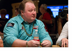 Greg Raymer in a bright blue shirt and a bracelet around his wrist