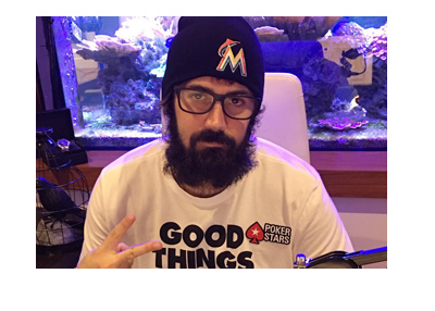 Poker player - Jason Mercier - giving a peace sign to his listeners.  Radio show.