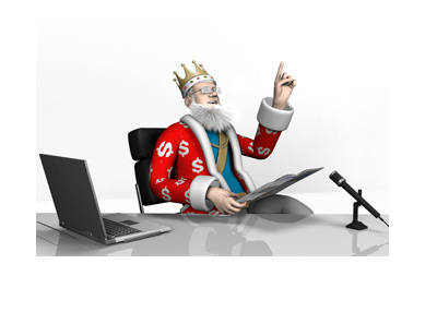 The King is sitting at his office desk. Glasses on. Excited. Pointing up.