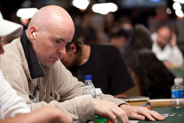 poker player john hennigan at the table with white ipod earphones